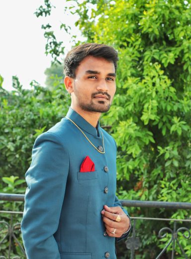 portrait-young-man-standing-against-plants